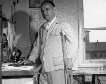 Foto tradizionale ungherese degli anni '60: uomo con le stampelle in un laboratorio di cucito/lavoro.