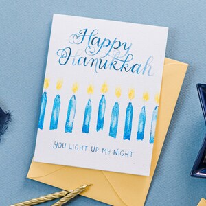 Jeu de mots carte Happy Hanukkah avec des bougies bleues de Hanoucca