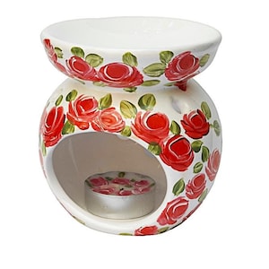 May include: White ceramic oil burner with a red rose floral design. The burner has a round base with a small opening for a tea light candle.
