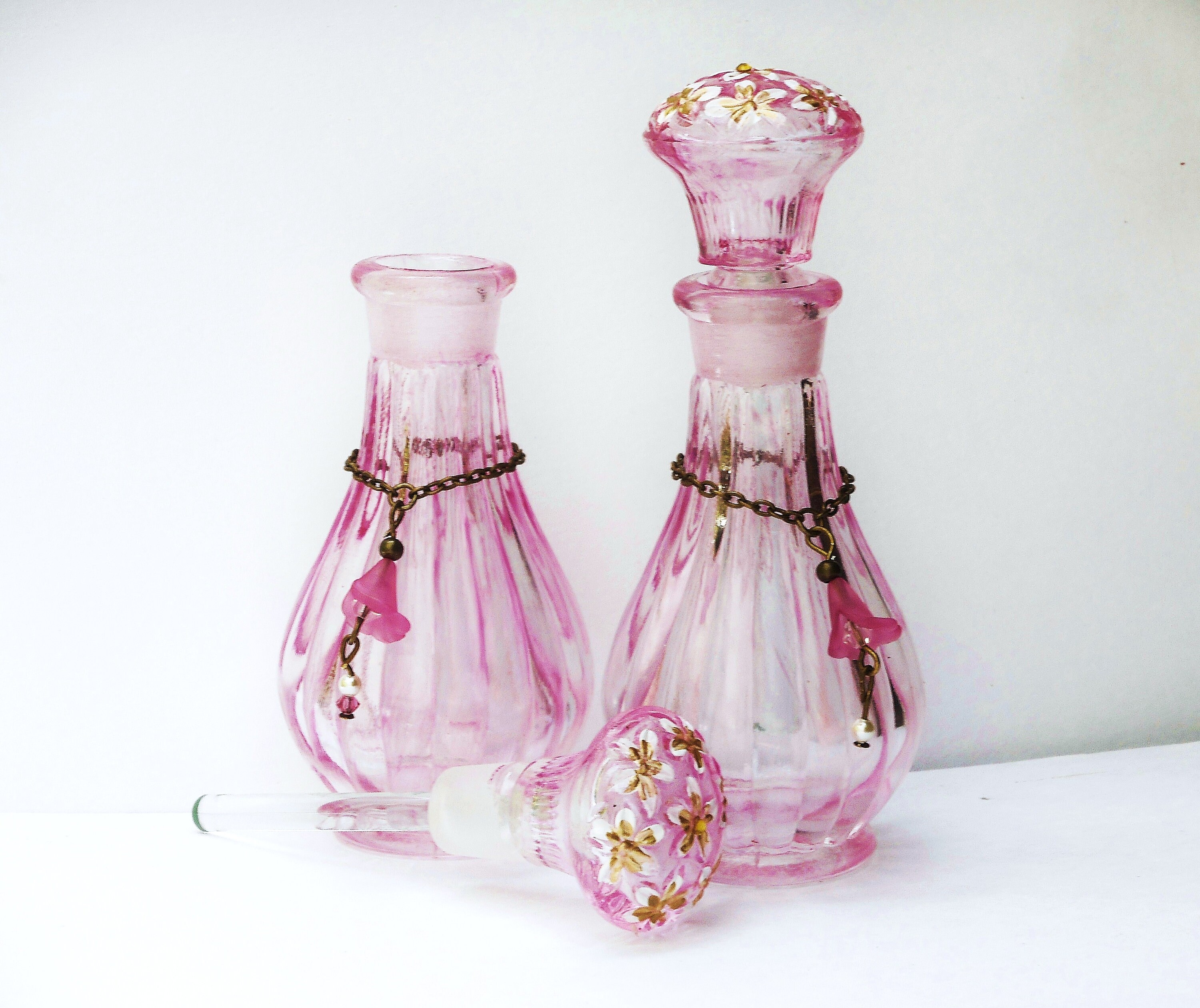小さなピンクのガラス製香水瓶、手描きの花柄、ロマンチックな