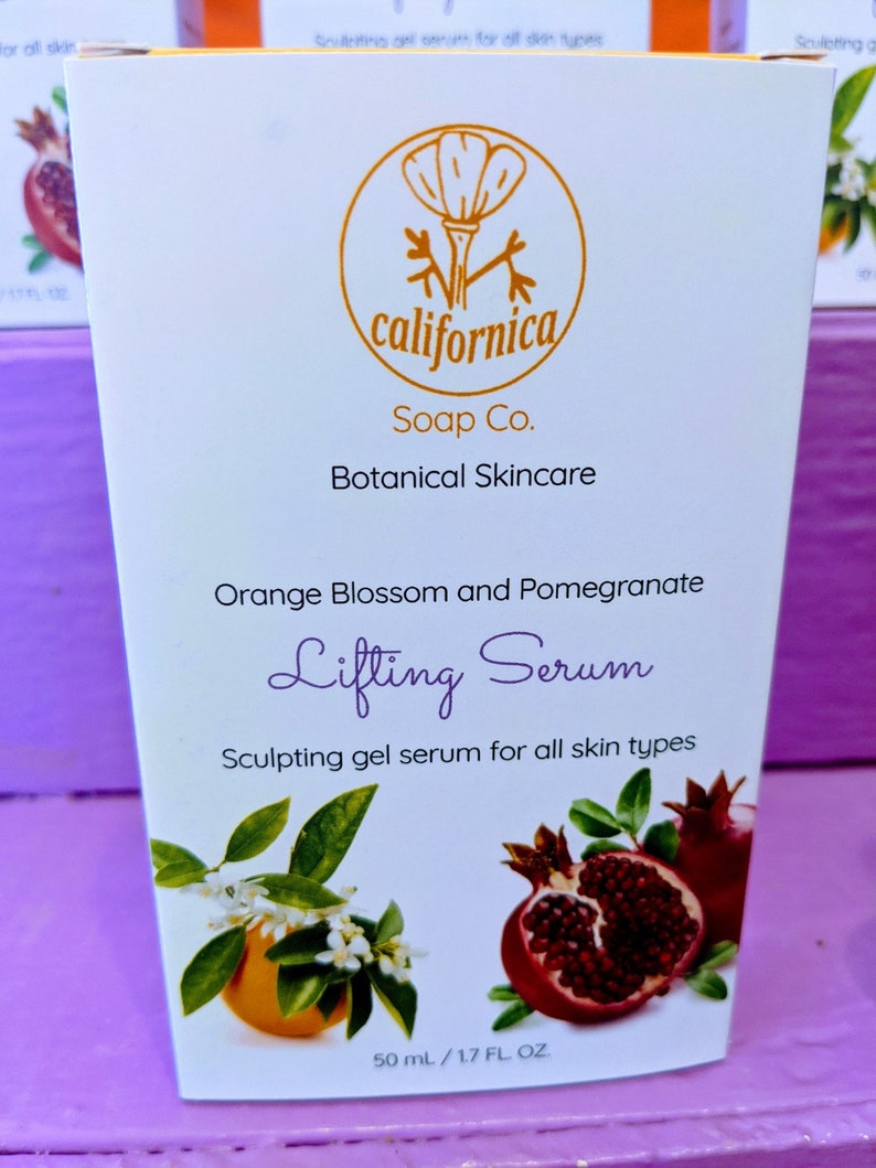 Puede incluir: Una caja blanca de cuidado de la piel bot&aacute;nico "californica Soap Co.". La caja presenta un logotipo dorado, texto e ilustraciones de flores de azahar, granadas y las palabras "Lifting Serum". El producto es un s&eacute;rum gel escultor para todo tipo de piel.