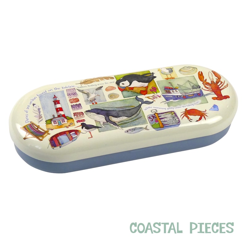 May include: A white and blue oval-shaped glasses case with a colorful illustration of a lighthouse, a whale, a puffin, a crab, and other sea life. The text "Pieces of the ocean found on the shoreline..." is printed on the case.