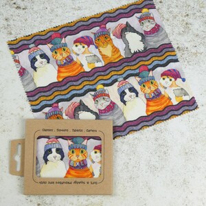 May include: A microfiber cleaning cloth with a colorful pattern of cats wearing winter hats and scarves. The cloth is packaged in a cardboard box with the text "Glasses - Screens - Tablets - Camera" and "Soft & Absorbent Microfibre Lens Cloth".