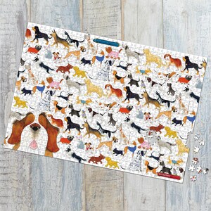 May include: A rectangular jigsaw puzzle featuring a multitude of dog illustrations in various breeds and poses. The puzzle pieces are white, and the dogs are depicted in a colorful, cartoonish style. Some pieces are missing.