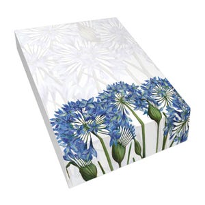 May include: A rectangular notepad featuring a watercolor illustration of blue agapanthus flowers at the bottom, with a faded white floral pattern on the top portion. The paper stack has a clean white edge and a smooth, flat surface texture.