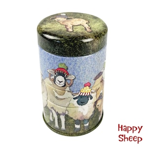 Puede incluir: Una lata cilíndrica con fondo azul y tapa verde. La lata presenta una ilustración caprichosa de ovejas con sombreros coloridos. El texto "Happy Sheep" está impreso en rojo en la parte inferior de la lata.