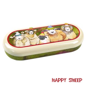 May include: A white oval-shaped glasses case with a green and brown background. The case features a colorful illustration of five sheep wearing knitted hats. The text "HAPPY SHEEP" is printed in red at the bottom of the image.