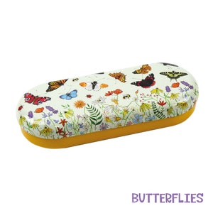 May include: A yellow and green eyeglasses case with a butterfly and flower design. The case is oval shaped and has a yellow rim.