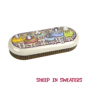May include: A white oval-shaped glasses case with a colorful illustration of sheep wearing sweaters. The case has a brown and black striped pattern on the bottom.