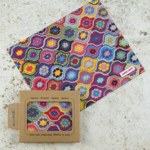 May include: A colorful crocheted microfiber cleaning cloth with a label that says "Janie Crow" and a brown cardboard box with the text "Soft & Absorbent Microfibre Lens Cloth" and "Glasses - Screens - Tablets - Cameras".