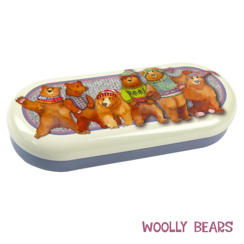 May include: A white and blue oval-shaped glasses case with a colorful illustration of six bears wearing winter hats and sweaters. The text "WOOLY BEARS" is printed in pink letters below the case.