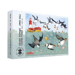 May include: A jigsaw puzzle box featuring a colorful illustration of puffins diving into the sea. The puzzle is titled "Diving Puffins" and is 64cm x 48cm in size. The box has a white background with text and a colorful image of puffins and fish.