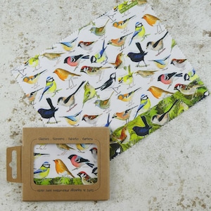 May include: A set of two microfiber cleaning cloths with a bird pattern. The cloths are packaged in a brown cardboard box with the text "Classes. Screens. Tablets. Camera" and "Soft & Squidgy microfibre lens cloth" printed on it. The cloths are white with a variety of colorful birds printed on them. The text "Eric Heymans" is printed in the top left corner of the cloth.