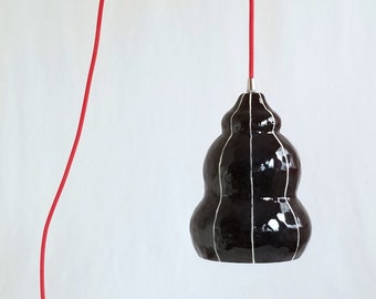 Black ceramic pendant light fixture. Pottery hanging lamp with red plugin cord