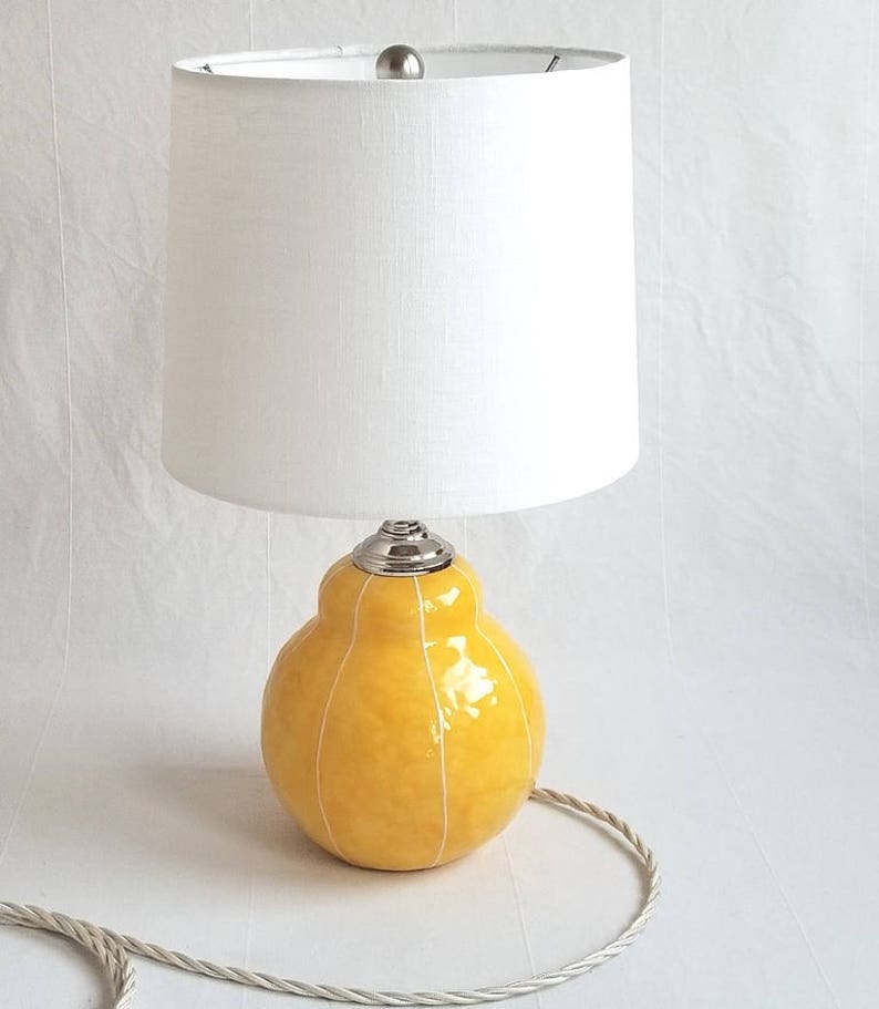 Handmade lamp in gray with white stripes. Organic, geometric base topped with white linen shade