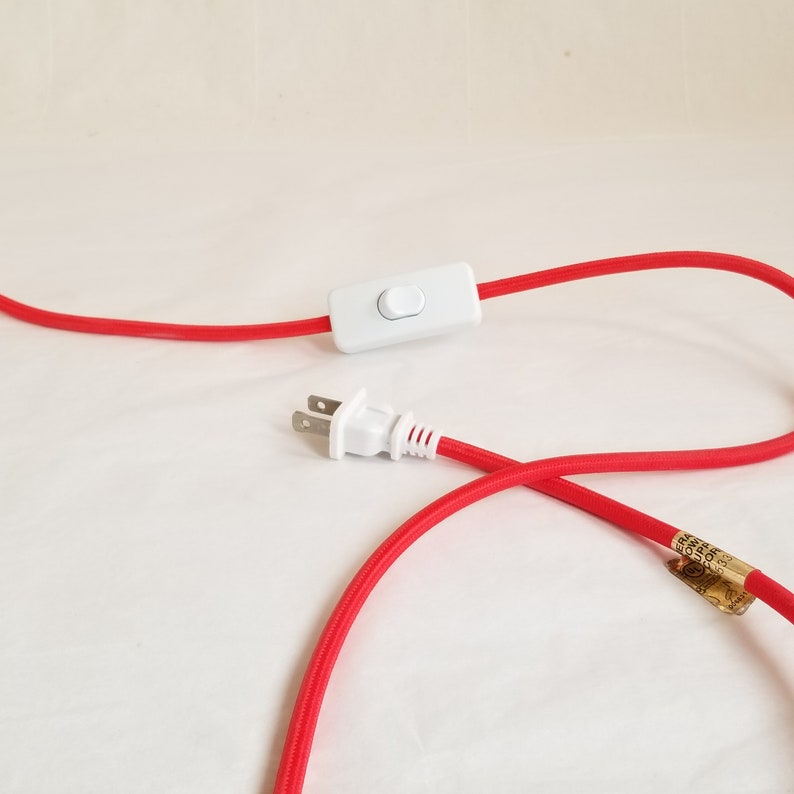 Detail of red plugin cord showing thumb switch and plug