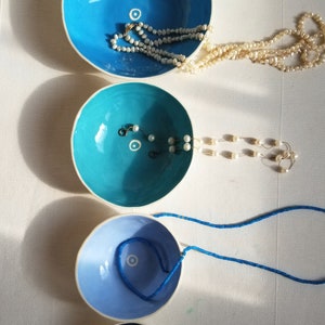 set of 4 nesting dishes in different shades of blue shown with jewelry