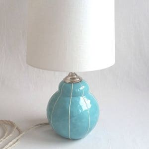 Handmade light turquoise ceramic table lamp with white stripes and white shade
