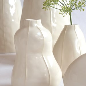 Close up of 3 white ceramic bud vases handmade  with thin, raised white stripes