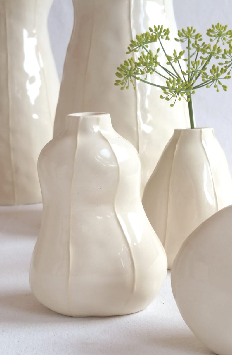 Close up of 3 white ceramic bud vases handmade  with thin, raised white stripes