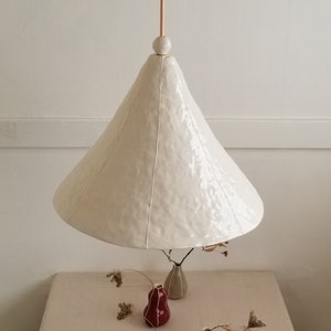 Large, 15" diameter, white cone pendant light with bead detail. Hangs over table. Overhead view