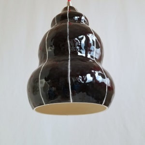 Underside of Black ceramic pendant light with thin white stripes