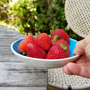 small turquoise blue bowl with strawberries. Side view