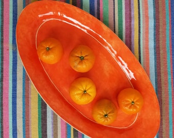 Handmade oval ceramic serving platter in coral orange