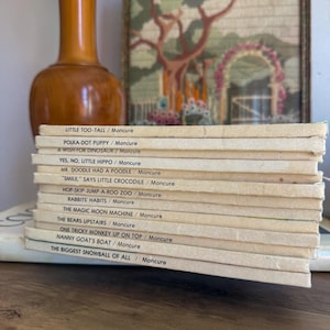 May include: A stack of twelve vintage children's books with cream-colored spines. Each spine features black text listing titles such as Little Too-Tall, Polka-Dot Puppy, A Wish for Dinosaur, Yes, No, Little Hippo, Mr. Doodle Had a Poodle, and others.