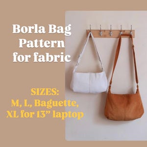 May include: Two fabric bags, one white and one tan, hang on a wooden rack. The text "Borla Bag Pattern for fabric" is displayed above the bags. The text also lists bag sizes: M, L, Baguette, and XL for a 33 cm laptop.