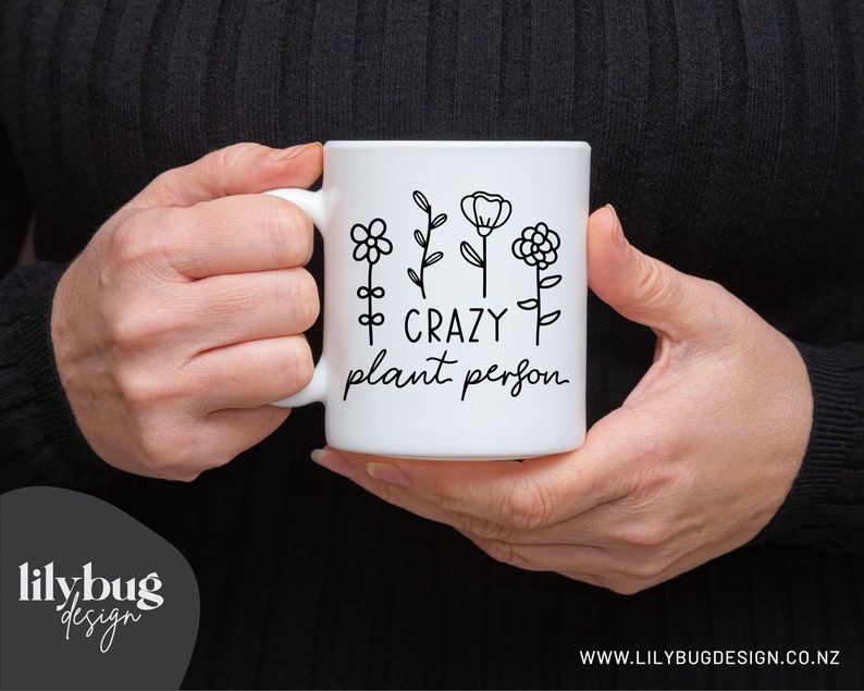 May include: White ceramic mug with a black outline of flowers and the text "Crazy plant person".