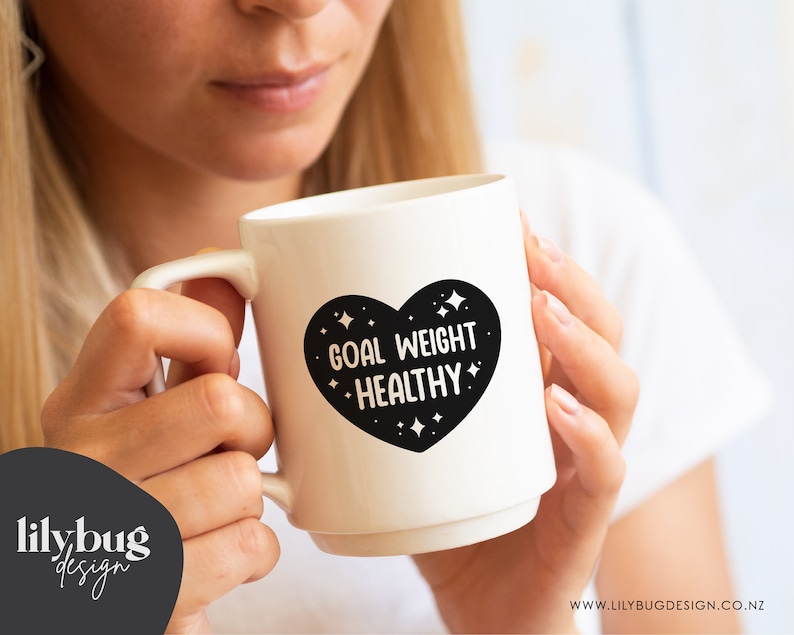 K&ouml;nnte beinhalten: Wei&szlig;e Keramiktasse mit einem schwarzen Herzdesign, auf dem "Goal Weight Healthy" mit wei&szlig;en Sternen um das Herz steht.