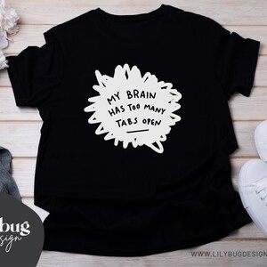 May include: Black t-shirt with white text that reads "My brain has too many tabs open".