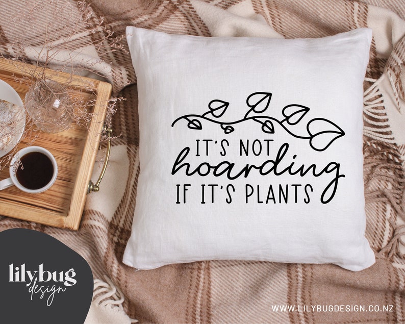May include: White throw pillow with black text that reads "It's not hoarding if it's plants." The text is surrounded by a vine with leaves.