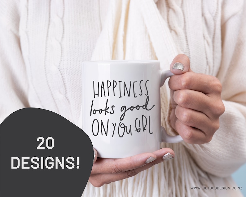 May include: White ceramic mug with black handwritten text that reads "Happiness looks good on you girl".