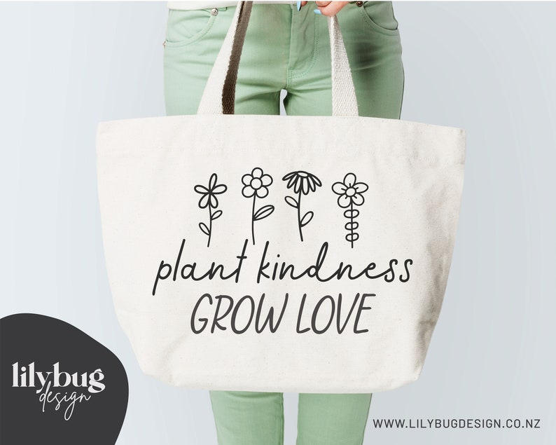 Op de afbeelding: Witte tote bag met zwarte tekst en bloemenillustraties met de tekst "plant kindness grow love".