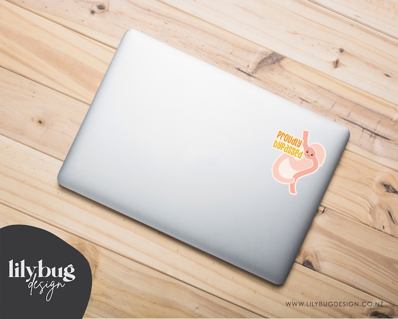 K&ouml;nnte beinhalten: Ein silberner Laptop mit einem Aufkleber eines Cartoon-Magens mit einem l&auml;chelnden Gesicht und dem Text "Proudly Bypassed".