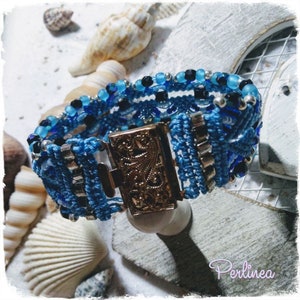 Puede incluir: Un brazalete azul y plateado con un cierre decorativo. El brazalete est&aacute; hecho de cord&oacute;n trenzado y presenta cuentas azules y plateadas.