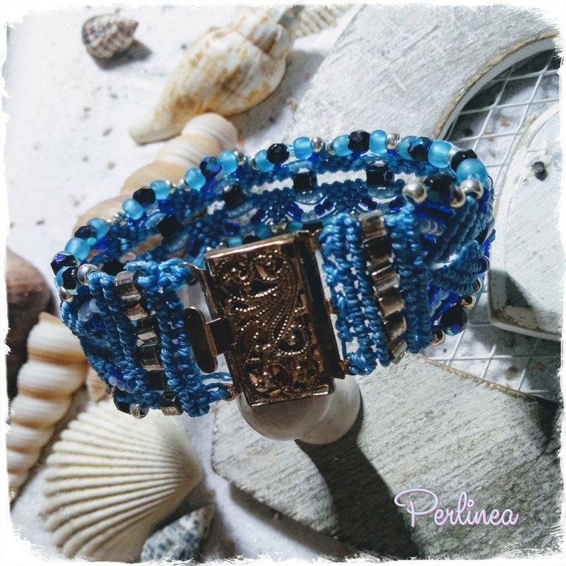 Puede incluir: Un brazalete azul y plateado con un cierre decorativo. El brazalete est&aacute; hecho de cord&oacute;n trenzado y presenta cuentas azules y plateadas.