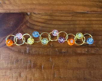 Row Counting Stitch Marker - Transparent Rainbow with Gold Rings.
