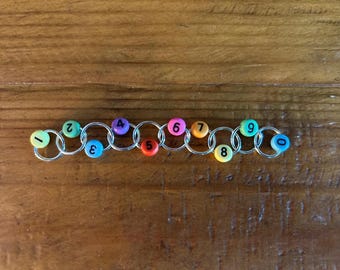 Row Counting Stitch Marker - Rainbow with black numbers.