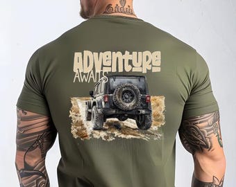 May include: A green t-shirt with a graphic of a jeep driving through a dirt road. The text "Adventure Awaits" is printed above the jeep.
