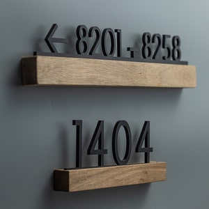 May include: Two wooden shelves with black numbers on them. The top shelf has an arrow pointing left and the numbers "8201 - 8258". The bottom shelf has the number "1404".