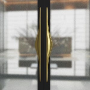 K&ouml;nnte beinhalten: Zwei schwarze T&uuml;ren mit goldfarbenen, l&auml;nglichen rautenf&ouml;rmigen Griffen. Die Griffe sind vertikal ausgerichtet und haben ein schlankes, modernes Design. Der Hintergrund ist verschwommen und zeigt einen Blick in einen Raum.