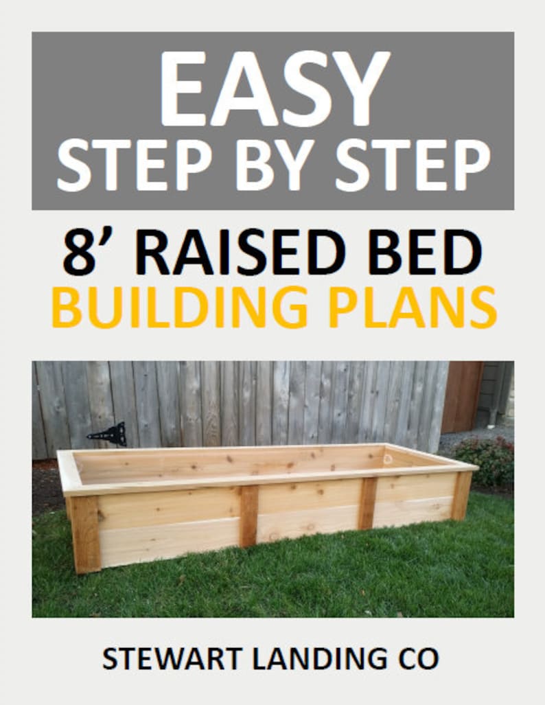 May include: A wooden raised garden bed, 8 feet long, made of cedar planks. The bed is sitting on a green lawn in front of a wooden fence. The text "EASY STEP BY STEP 8' RAISED BED BUILDING PLANS STEWART LANDING CO" is displayed on the image.