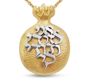Puede incluir: Un collar de oro con un colgante de granada con letras hebreas. El colgante es texturizado y tiene un diseño de dos tonos con acentos de oro blanco.