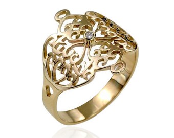 Könnte beinhalten: Ein goldener Filigranring mit einem kleinen Diamanten in der Mitte. Der Ring ist in einem filigranen, komplizierten Muster gestaltet.