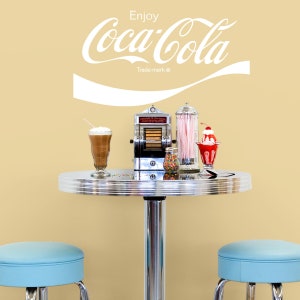 Enjoy Coca-Cola 1970s Script Vinyl Wall Decal is available in Red or White Colored Vinyl. Shown here in a diner settings.