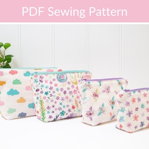 May include: Four different zippered pouches with various colourful patterns. The pouches are lined up from largest to smallest. The patterns include clouds, flowers, bees, and more flowers.