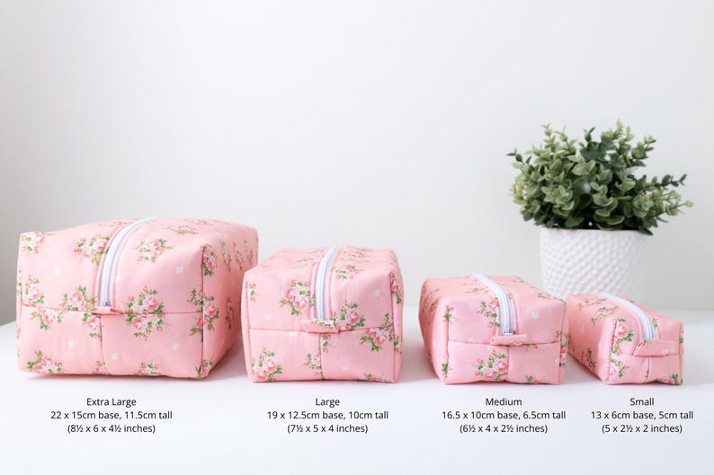 May include: Four rectangular pink pouches with a floral pattern and white polka dots, featuring white zippers. Sizes include: Extra Large 8.5 x 6 x 4.5 inches, Large 7.5 x 5 x 4 inches, Medium 6.5 x 4 x 2.5 inches, and Small 5 x 2.5 x 2 inches.